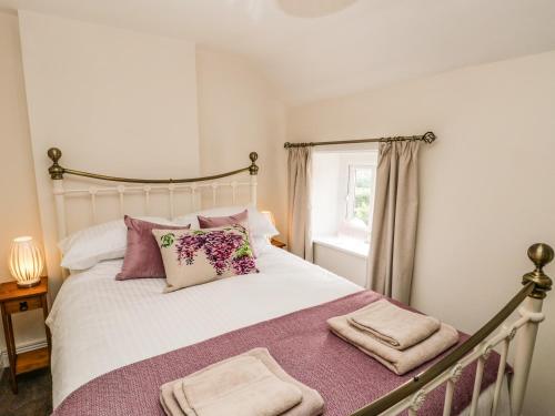 a bedroom with a bed with pillows and a window at Chapel Cottage in Redcar