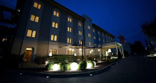 a building with lights in front of it at night at Best Western Grand Hotel Guinigi in Lucca