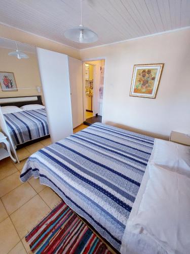 a bedroom with a blue and white striped bed at Villa Riva in Molunat