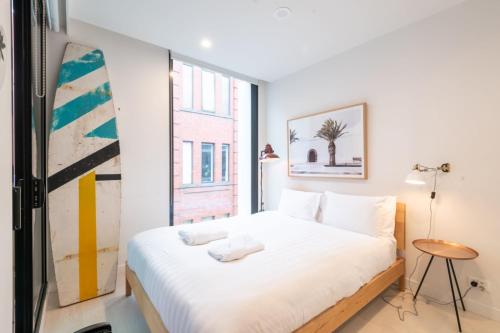 1 dormitorio con cama blanca y ventana en Trendy 1 Bedroom Apartment in the Heart of Collingwood, en Melbourne