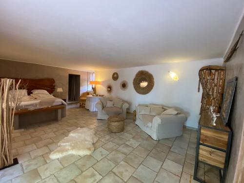 sala de estar con 2 sillas blancas y 1 cama en Domaine De Sainte Annette, en Callian