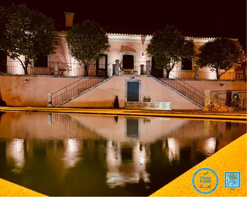a building with a pool of water at night at CASA DA TRINCHEIRA , turismo de habitação in Pinhel