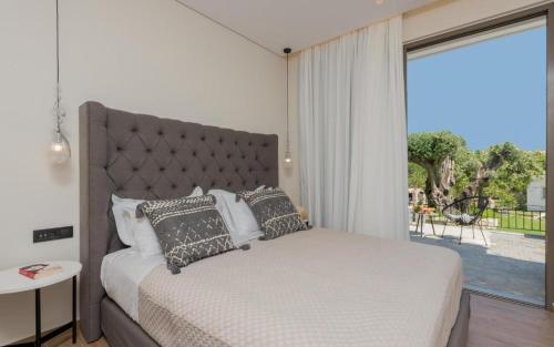 a bedroom with a large bed and a large window at Eptanisos Beachfront Suites Zante in Keri