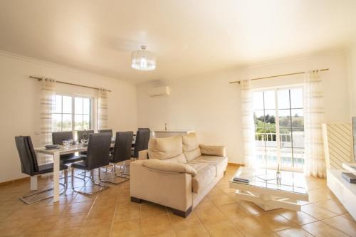 a living room with a couch and a table at Villa Rosa - with private pool in Alcantarilha