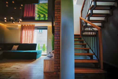 a living room with a staircase and a blue couch at Na Skraju Raju in Zator
