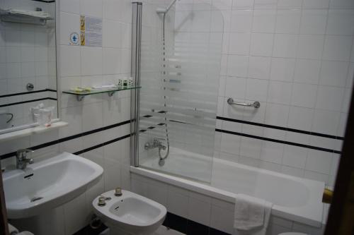 a bathroom with a sink and a shower and a toilet at Hotel Playa de Regla in Chipiona