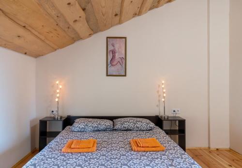 a bedroom with a bed with two orange pillows on it at Sonyachni bungalo in Melʼniki