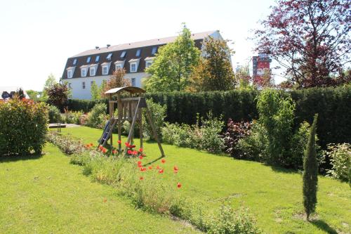 a garden with a swing in the grass at Appartements Vanii in Rust