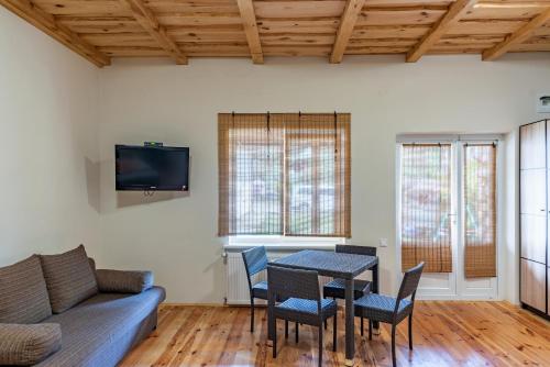 a living room with a table and chairs and a couch at Sonyachni bungalo in Melʼniki