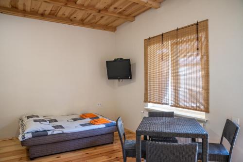a room with a bed and a table and a tv at Sonyachni bungalo in Melʼniki