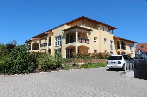 a car parked in front of a large house at Appartements Vanii in Rust