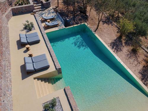 una vista aérea de una piscina con 2 tumbonas en Aelia & Melitta Villas, en Perdika