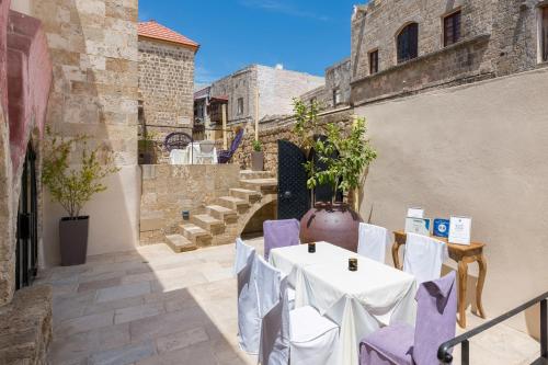 a table and chairs in a courtyard with stairs at Allegory Boutique Hotel in Rhodes Town