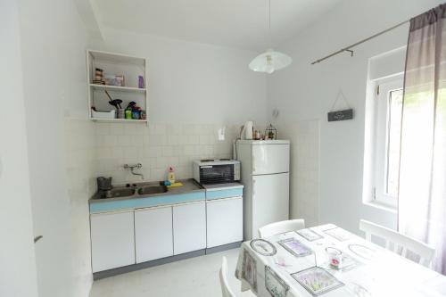 a small kitchen with a sink and a refrigerator at Apartment Room with a view in Podgora