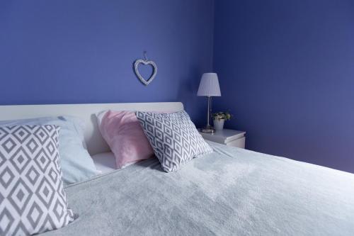 a bedroom with purple walls and a bed with pillows at Apartment Room with a view in Podgora