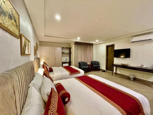a hotel room with two beds and a television at Shelton's Ambassador in Islamabad