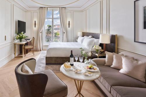 a hotel room with a bed and a couch and a table at Mandarin Oriental, Ritz Madrid in Madrid