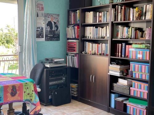 een kamer met een boekenplank gevuld met boeken bij Le chasse marée in Offranville