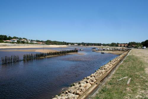 a body of water with rocks and a beach at Single Fin Hotel & Lodge in Mimizan-Plage