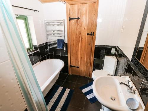 a bathroom with a tub and a sink and a toilet at Trewrach Cottage in Newport Pembrokeshire