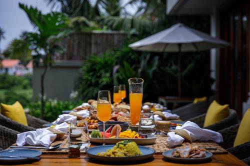 un tavolo con piatti di cibo e bicchieri di succo d'arancia di Baale Resort Goa ad Arpora