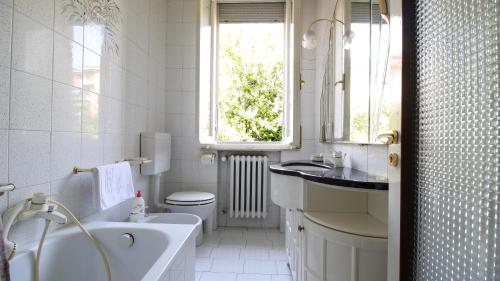 a white bathroom with a tub and a sink at Residenza Parco Ducale 2 in Parma