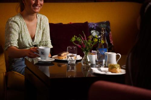 a woman sitting at a table with plates of food at Horse & Jockey Hotel in Horse and Jockey