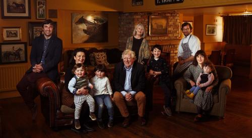 a family posing for a picture in a living room at Horse & Jockey Hotel in Horse and Jockey