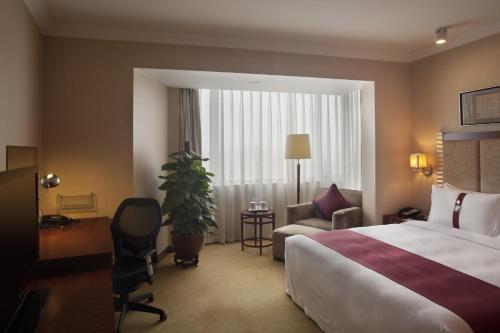 a hotel room with a bed and a couch and a chair at Holiday Inn Temple Of Heaven Beijing by IHG in Beijing
