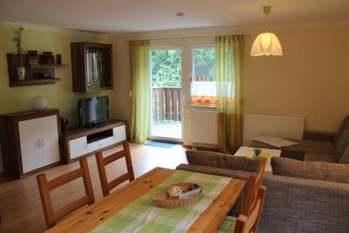 ein Wohnzimmer mit einem Tisch und einem Sofa in der Unterkunft Ferienwohnungen Margaretenhof, Plaue in Margarethenhof
