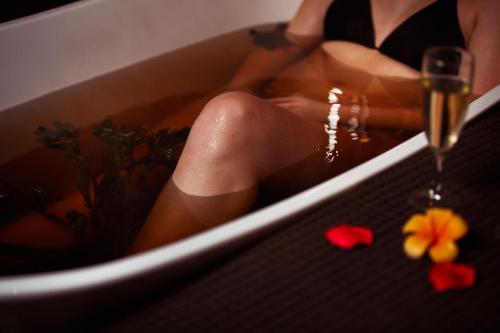 a woman is sitting in a bath tub with flowers at Horse & Jockey Hotel in Horse and Jockey