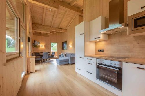 a kitchen with white cabinets and a living room at Haus Alpenprinzessin in Neustift im Stubaital