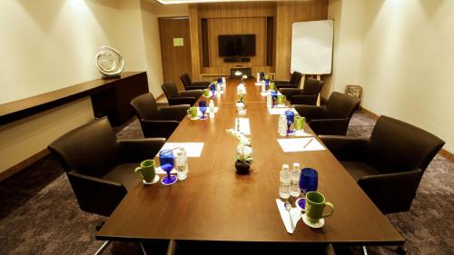 a conference room with a long wooden table and chairs at Holiday Inn Gurugram Sector 90 by IHG in Gurgaon
