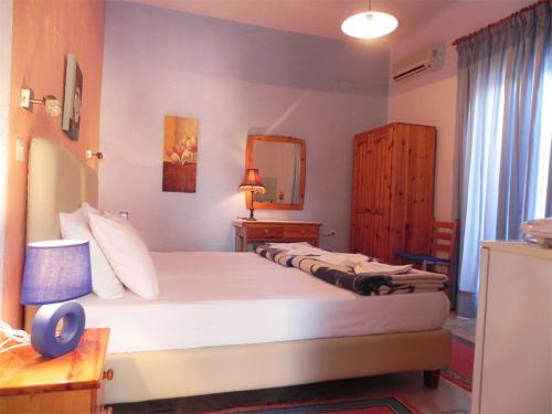 um quarto com uma grande cama branca num quarto em Aggelos Studios em Panormos Kalymnos