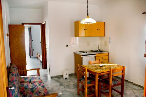 a kitchen with a wooden table and a kitchen with a stove at Popi Hotel Apartments in Agia Marina Nea Kydonias