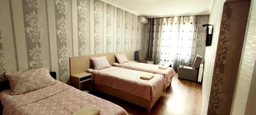 um quarto de hotel com duas camas e uma janela em Hotel VENUS em Tbilisi