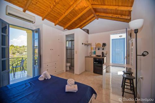 sypialnia z niebieskim łóżkiem i kuchnią w obiekcie Studio Gerani 1 w mieście Porto Heli