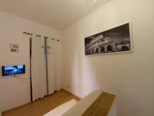 una camera bianca con una foto sul muro di Gladiator's House a Roma