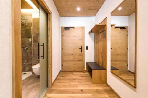 a bathroom with a walk in shower and a toilet at Wohlfühlhotel Berg Heil in Holzgau