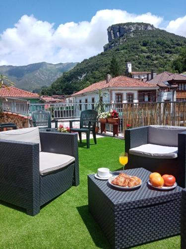 a patio with chairs and a table with a plate of food at Hotel Rural Cabrales in Carreña de Cabrales 