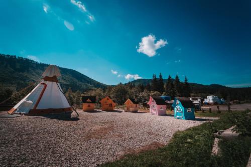 a group of tents on a gravel field with a mountain at Ranč pod Ostrou Skalou in Stratená