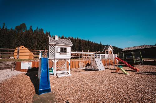 a playground with play equipment and a house at Ranč pod Ostrou Skalou in Stratená