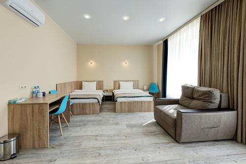Habitación hospitalaria con 2 camas y mesa en Hotel Berg Haus, en Tver