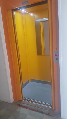 a bathroom with a yellow door and a mirror at Apartmán U kolonády in Mariánské Lázně
