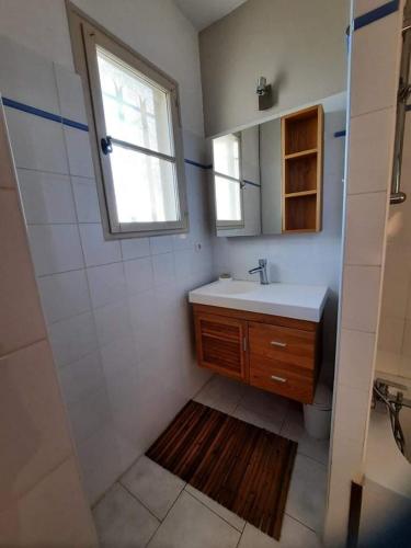 une salle de bain avec un lavabo et une fenêtre dans l'établissement Les Néfliers, à Maillane