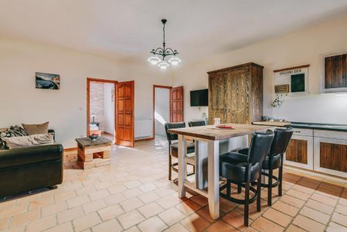 a kitchen and living room with a table and chairs at Matild Country Hotel in Nemesvita