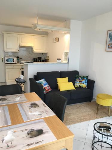 un salon avec un canapé et une table dans l'établissement Cap'tain Kipper , vue mer, 2 chambres , garage fermé , Wimereux, à Wimereux