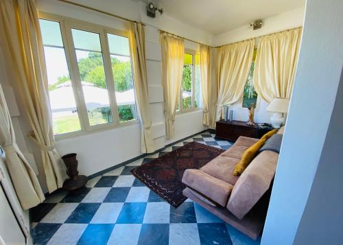 a living room with a couch and windows at Affittacamere Torre Dell'Arte in Torre del Lago Puccini
