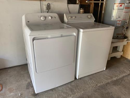 - un lave-linge et un sèche-linge blancs installés dans un garage dans l'établissement 6 Bedroom house 15 minutes from iah airport., à Houston