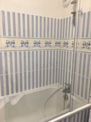 La salle de bains est pourvue d'une baignoire avec des arcs sur le mur. dans l'établissement Cap'tain Kipper , vue mer, 2 chambres , garage fermé , Wimereux, à Wimereux